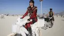 Seorang wanita saat mengendarai sepeda hiasnya selama acara The Burning Man 2015 atau " Carnival of Mirrors " di sebuah gurun pasir, Nevada ,(31/8/2015). Acara ini menghadirkan berbagai pertunjukan seni seperti music dan tari. (REUTERS/Jim Urquhart)
