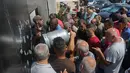Warga Lebanon menunggu untuk mengisi tabung gas di kota selatan Sidon, Selasa (10/8/2021). Warga Lebanon harus mengantre panjang demi membeli gas untuk memasak di tengah krisis ekonomi parah yang memicu kelangkaan berbagai kebutuhan pokok dari obat-obatan hingga bahan bakar. (Mahmoud ZAYYAT/AFP)