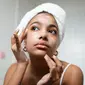 Ilustrasi perempuan yang sedang membersihkan wajahnya menggunakan pembersih wajah untuk kulit kering dan beruntusan. Credits: pexels.com by Ron Lach