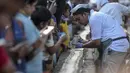 Seorang tukang roti menyelesaikan kue sepanjang 6,5 km untuk kue terpanjang dunia, di Thrissur di negara bagian Kerala, India selatan (15/1/2020). Dibutuhkan 12 ribu kilogram gula dan tepung dan menghabiskan waktu lebih dari empat jam untuk membuat kue terpanjang itu. (AFP/Arun Sankar)
