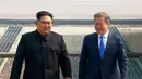 Pemimpin Korea Utara Kim Jong-un dan Presiden Korea Selatan Moon Jae-in berjalan melewati Zona Demiliterisasi, Jumat (27/4). Kim dan Moon menuju Rumah Perdamaian di wilayah Korsel untuk menggelar pertemuan tingkat tinggi (Korea Broadcasting System via AP)