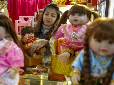 Supattar Wichainan mendadani boneka Look Thep (anak malaikat) di sebuah toko di department store, Bangkok, Selasa (26/1). Boneka yang diisi dengan roh anak kecil melalui ritual tertentu itu dianggap bisa membawa keberuntungan (REUTERS/Athit Perawongmetha)