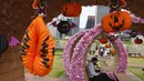Seorang pria yang mengenakan masker untuk mencegah penyebaran virus corona, beristirahat di dekat beberapa dekorasi Halloween di sebuah taman di Hong Kong, Rabu (27/10/2021). Tahun ini, perayaan tersebut jatuh pada hari Minggu, 31 Oktober 2021. (AP Photo/Vincent Yu)