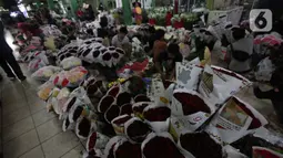 Para pekerja merangkai bunga di Pasar Rawa Belong, Jakarta, Jumat (29/10/2021). Status PPKM di DKI Jakarta yang diturunkan dari level 3 menjadi level 2 berimbas dengan penjualan bunga untuk dekorasi pernikahan yang kembali ramai, seperti di Pasar Bunga Rawa Belong. (Liputan6.com/Johan Tallo)