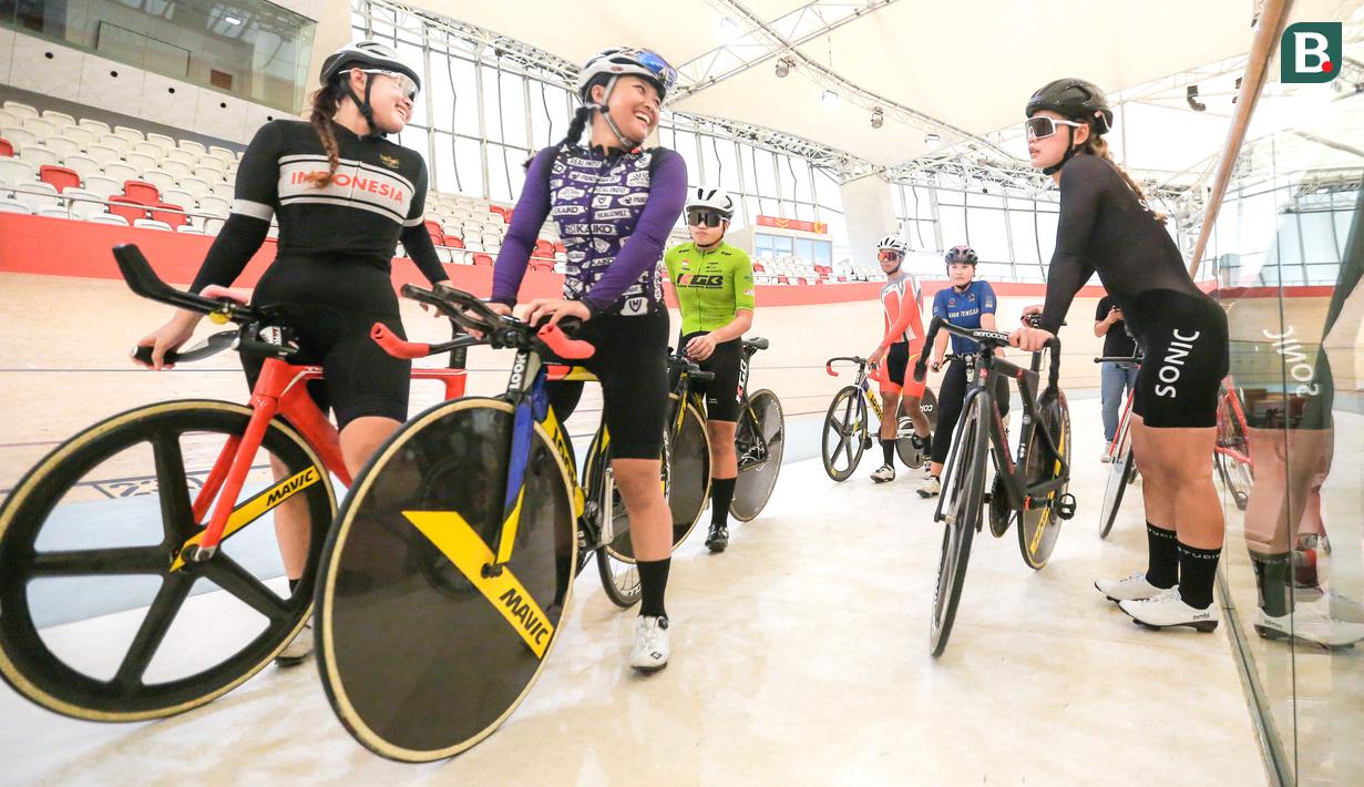 Pebalap sepeda putri Indonesia, Ayustina Delia Priatna (kanan) bercengkrama dengan rekannya saat berlatih untuk ajang UCI Track Nations Cup 2023 di Jakarta International Velodrome, Rawamangun, Jakarta, Kamis (16/02/2023). (Bola.com/Bagaskara Lazuardi)