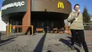 Seorang perempuan berjalan melewati restoran McDonald's yang tertutup untuk pengunjung di St. Petersburg, Rusia, Selasa (15/3/2022). Penutupan ini dilakukan pihak McDonald's sebagai sikap atas invasi Rusia ke Ukraina yang berlangsung dari 24 Februari 2022 lalu. (AP Photo)