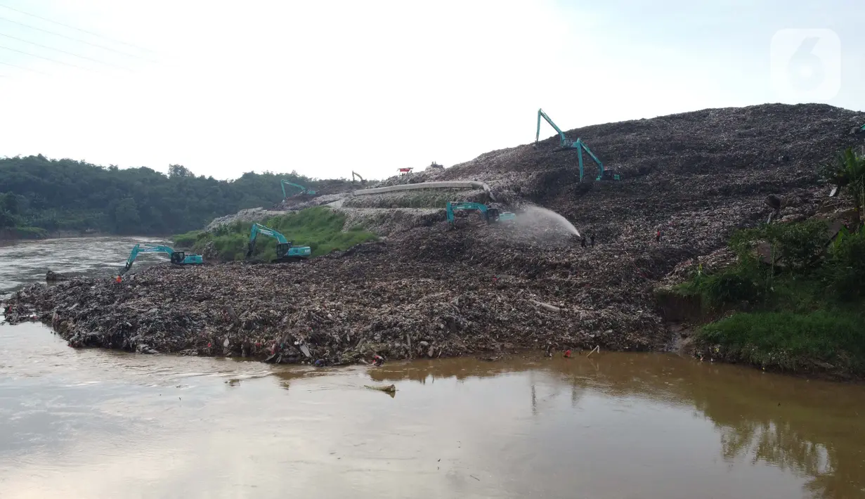 Foto udara memperlihatkan tumpukan sampah dari Tempat Pembuangan Akhir (TPA) Cipeucang masuk ke area Sungai Cisadane, Serpong, Tangerang Selatan, Rabu (3/6/2020). Sebelumnya, pada Jumat (22/5/) lalu turap yang menopang tumpukan sampah di TPA tersebut jebol. (Liputan6.com/Helmi Fithriansyah)