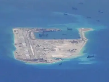 Kapal pengeruk disekitar terumbu karang Fiery Cross Reef di laut Cina selatan, (21/5/2015). Menurut Asia Maritime Transparency Initiative (AMTI) Cina mereklamasi sedikitnya 3 juta meter kubik tanah untuk buat pangkalan Militer. (REUTERS / A.S . Navy)