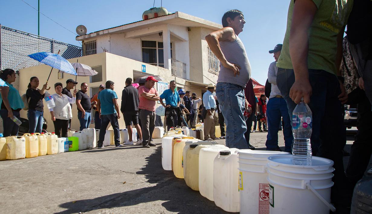 Warga antre menggunakan jerigen di tengah kelangkaan BBM di sebuah SPBU di Morelia, Meksiko, Selasa (8/1). Antrean disebabkan pasokan BBM ke beberapa negara bagian di Meksiko mengalami kekurangan akibat kasus pencurian bahan bakar. (ENRIQUE CASTRO/AFP)