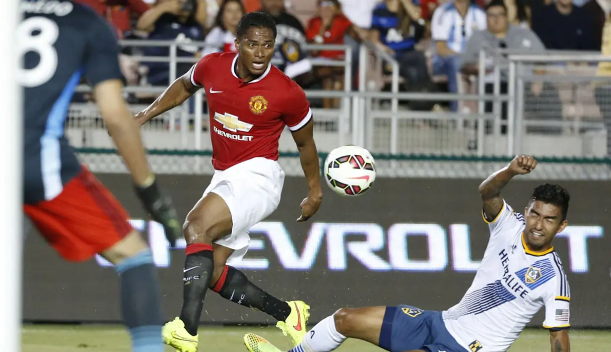 Gelandang Manchester United, Antonio Valenica (kiri) mencoba melewati hadangan pemain LA Galaxy, AJ DeLaGarza, saat berlaga di Rose Bowl, Kalifornia, (23/7/2014). (REUTERS/Lucy Nicholson)