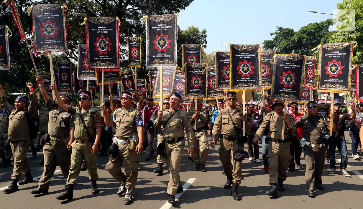 Buruh dari KRPI membentangkan spanduk saat Perayaan Peringatan Hari Buruh Sedunia, Jakarta, Selasa (1/5). Dalam karnaval dan deklarasi para buruh menyerukan 5 maklumat untuk di sampaikan kepada Presiden Joko Widodo. (Liputan6.com/Johan Tallo)