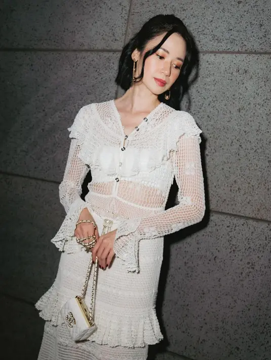 Dengan makeup yang glamor, Laura Basuki jinjing mini bag chain strap berwarna putih. Tampilannya semakin manis dengan aksesori dari Tiffany & Co. [@laurabas]