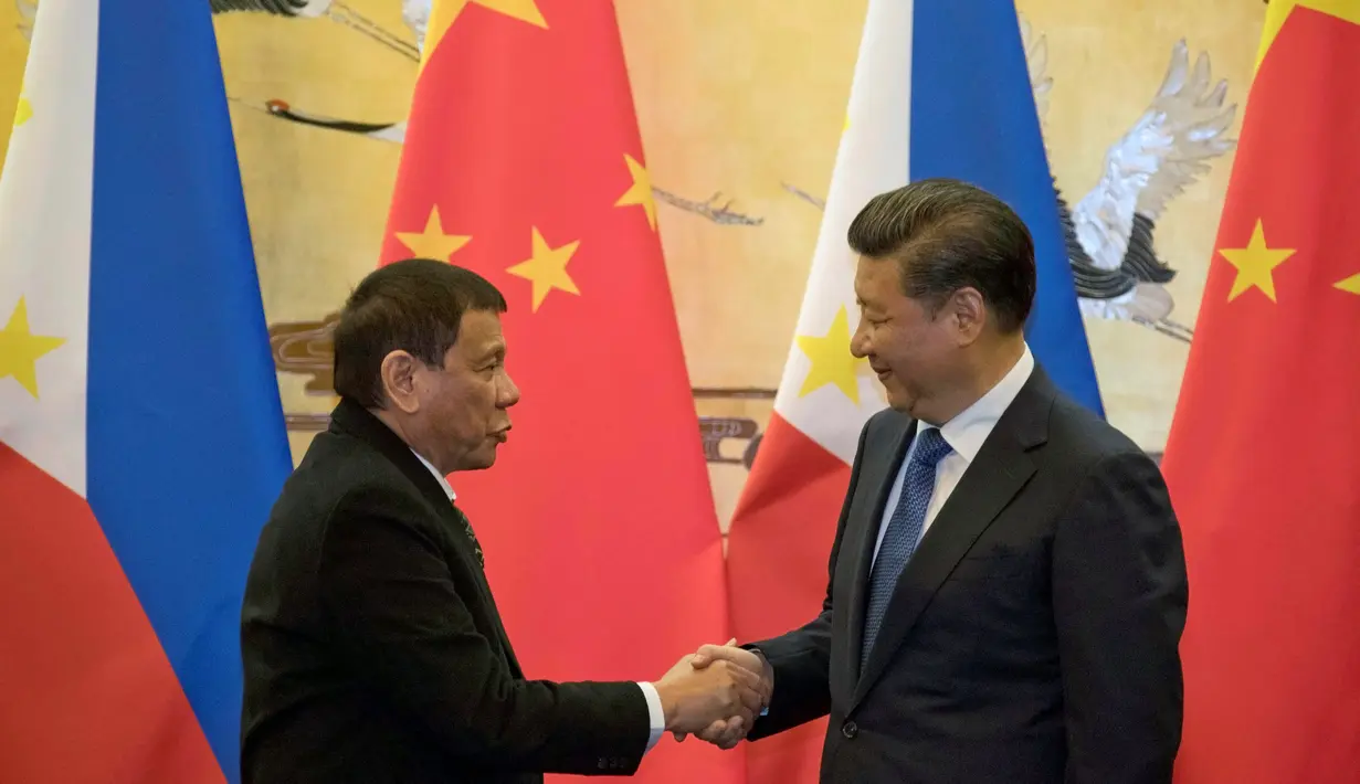 Presiden Filipina Rodrigo Duterte berjabat tangan dengan Presiden Xi Jinping seusai pertemuan dua negara di Beijing (20/10). Pertemuan tersebut membuat kebijakan luar negri Filipina yang lebih condong ke Tiongkok daripada ke AS. (Reuters/ Ng Han Guan)