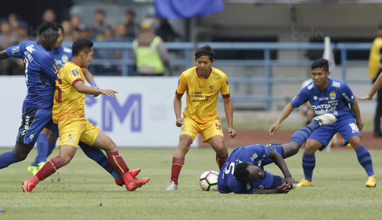 Gelandang Persib, Michael Essien, terjatuh saat pertandingan melawan Sriwijaya FC pada laga Piala Presiden di Stadion GBLA, Bandung, Selasa (16/1/2018). Persib menang 1-0 atas Sriwijaya FC. (Bola.com/M Iqbal Ichsan)