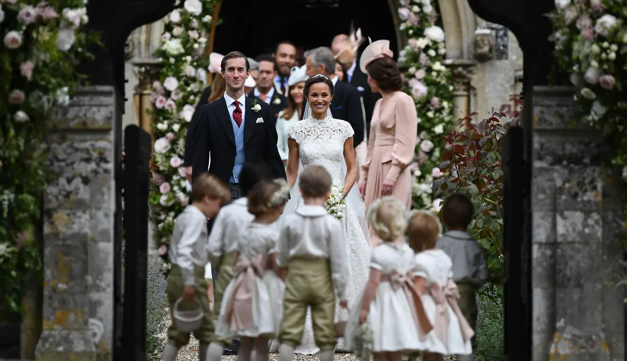 Pippa Middleton, adik Kate Middleton, dan James Matthews setelah mengikuti upacara pernikahan di Gereja St Mark, Englefield, Inggris, Sabtu (20/5). Adik ipar Pangeran William itu terlihat cantik mengenakan gaun karya Giles Deacon. (JUSTIN TALLIS/POOL/AFP)