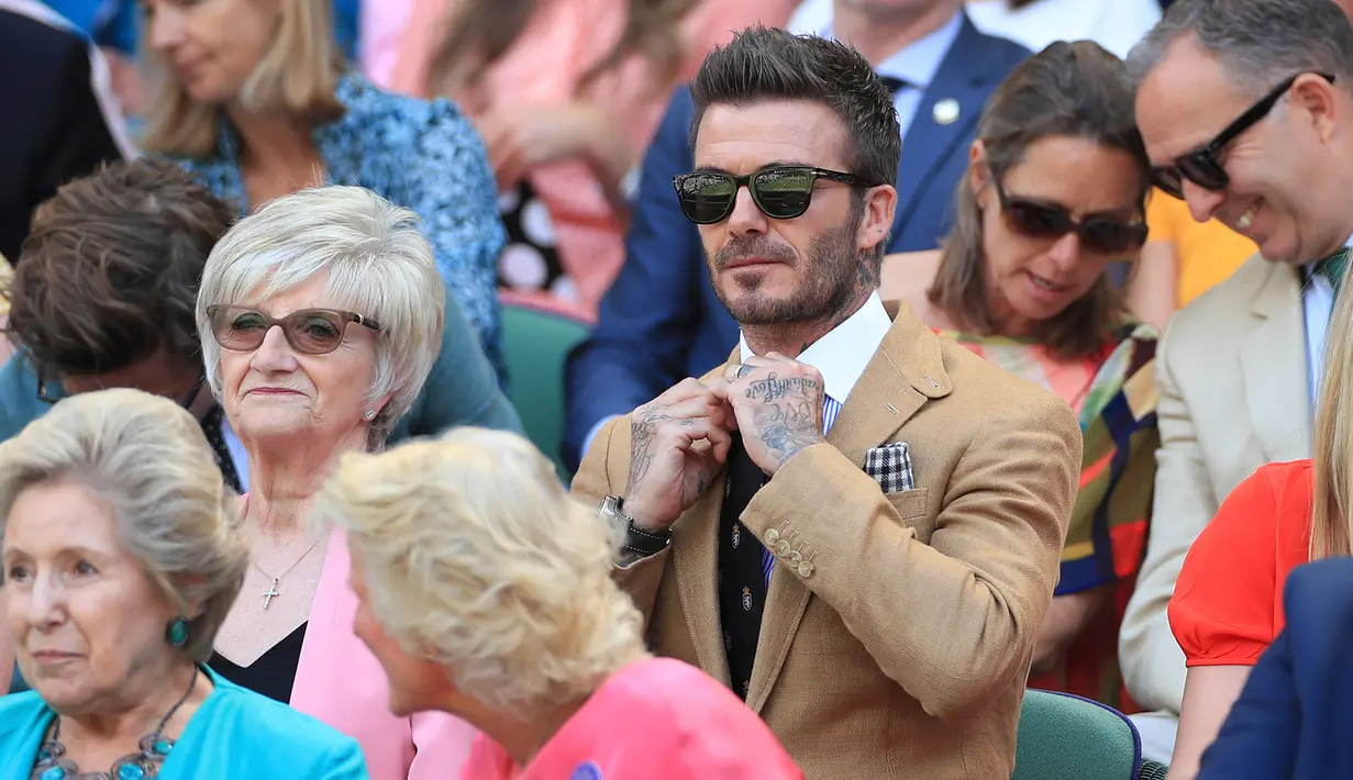 Mantan pesepak bola Inggris, David Beckham menyaksikan babak semifinal Grand Slam Wimbledon di All England Lawn Tennis Club, Kamis (11/7/2019). Beckham menjadi saksi petenis Rumania Simona Halep lolos ke final usai menang atas Elina Svitolina dari Ukraina 6-1, 6-3. (Mike Egerton/Pool Photo via AP)