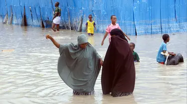 Wanita Somalia berjalan melewati air banjir saat hujan lebat di Mogadishu, Somalia, 20 November 2023. Banjir terburuk yang melanda Somalia dalam beberapa dekade telah menewaskan banyak orang dan memaksa ribuan orang meninggalkan rumah mereka. (AP Photo/Farah Abdi Warsameh)