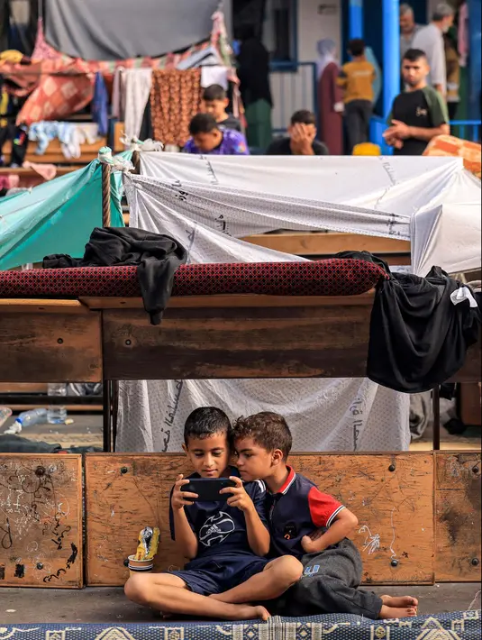 Sebuah sekolah diubah menjadi menjadi tempat penampungan bagi para pengungsi Palestina oleh Badan Bantuan dan Pekerjaan PBB untuk Pengungsi Palestina (UNRWA) di Khan Yunis, Jalur Gaza selatan pada 25 Oktober 2023. (MAHMUD HAMS/AFP)