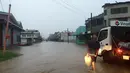 Seorang pria berjalan melewati genangan banjir yang melanda Ba, wilayah barat Fiji, Rabu (6/4). Otoritas Fiji memerintahkan warganya untuk tetap berada di dalam ruangan seiring semakin mendekatnya siklon Tropis Zena. (NAZIAH ALI/MAI LIFE MAGAZINE /AFP)
