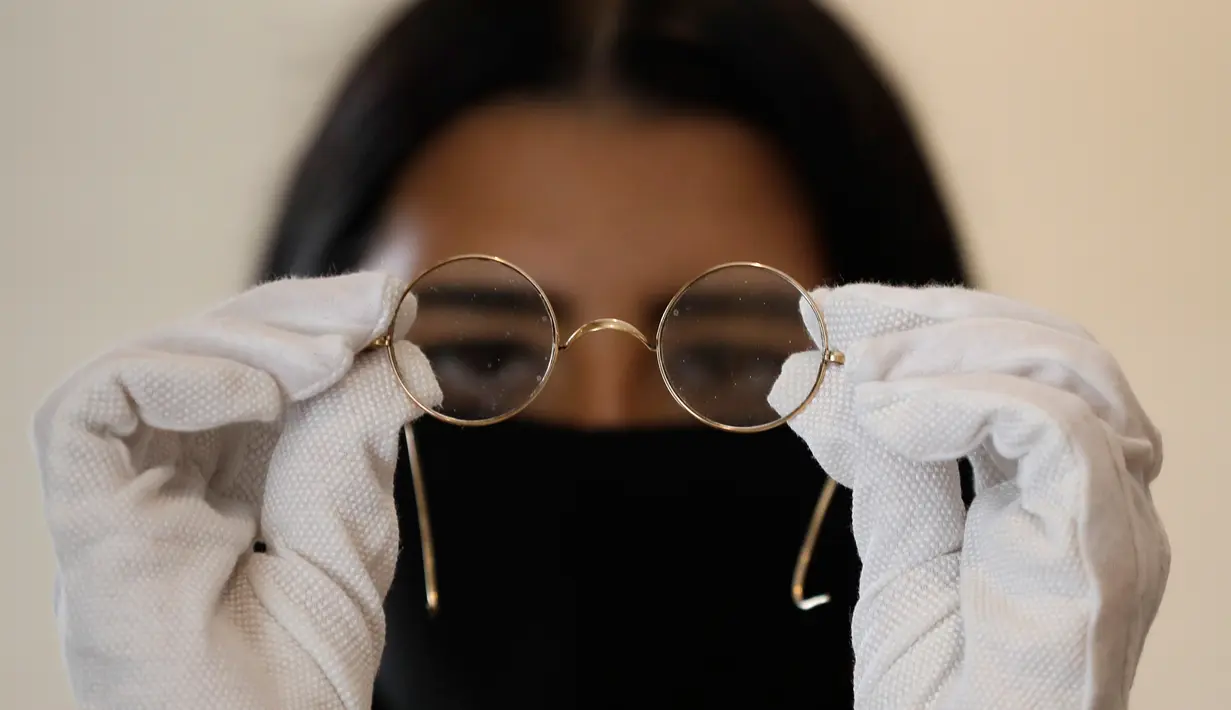Sepasang kacamata Windsor bulat milik John Lennon dipamerkan di ruang lelang Sotheby di London, pada 25 September 2020. Sotheby’s kembali mengadakan lelang online memorabilia Beatles pada September ini menandai 50 tahun bubarnya grup band legendaris asal Inggris itu. (AP Photo/Kirsty Wigglesworth)