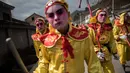 Sejumlah orang mengenakan kostum dan berdandan berjalan bersiap menguikuti festival She Huo di Longxian, provinsi Shaanxi, Tiongkok (27/2). Mereka berdandan dan mengenakan kostum yang mewakili tokoh legandaris setempat. (AFP Photo/Fred Dufour)