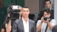 Cristiano Ronaldo berjalan untuk menyapa suporter saat tiba di pusat layanan kesehatan Juventus (J-Medical), Turin, Italia, (16/7). Juventus resmi mendatangkan Ronaldo dari Real Madrid seharga 100 juta euro. (AFP Photo/Miguel Medina)