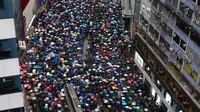 Pengunjuk rasa membawa payung saat menuju Victoria Park, Hong Kong, Minggu (18/8/2019). Puluhan ribu massa pro-demokrasi membawa payung saat hujan mengguyur Victoria Park dan sekitarnya. (AP Photo/Vincent Yu)
