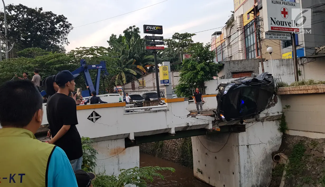 Petugas berusaha mengevakuasi mobil yang terguling di kawasan Pasar Minggu, Jakarta Selatan, Sabtu (8/6/2019) pagi. Mobil yang nyaris tercebur sungai itu dikendarai seorang pemuda yang nekat melakukan aksi kebut-kebutan saat jalanan ibu kota lengang. (Liputan6.com/Herman Zakharia)