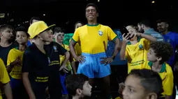 Anak-anak berdiri dekat  patung pemain sepak bola legendaris Brasil, Pele, di Museum Tim Sepak Bola Brasil di Rio de Janeiro, Kamis (20/2/2020). Konfederasi Sepak Bola Brasil meluncurkan patung Pele sebagai bagian dari peringatan 50 tahun sejak kemenangan Piala Dunia 1970. (AP/Leo Correa)