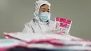 Seorang pekerja membuat masker di ruang produksi sebuah perusahaan produsen barang kebutuhan medis di Kota Jiaozuo, Provinsi Henan, China tengah, pada 9 Februari 2020. (Xinhua/Feng Xiaomin)