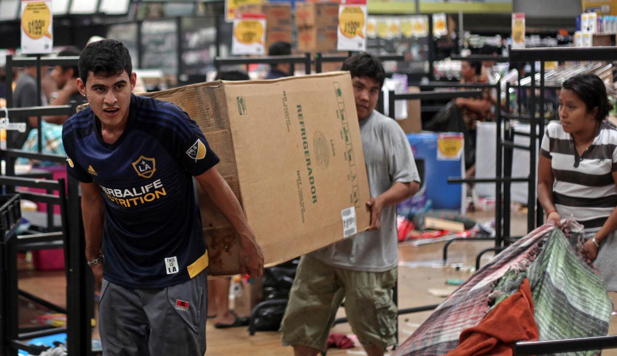 Warga membawa kulkas dari toko yang dijarah di Veracruz, Meksiko, (5/1). Akibat kejadian tersebut mengakibatkan kematian seorang polisi dan seorang saksi. (AP Photo / Felix Marquez)