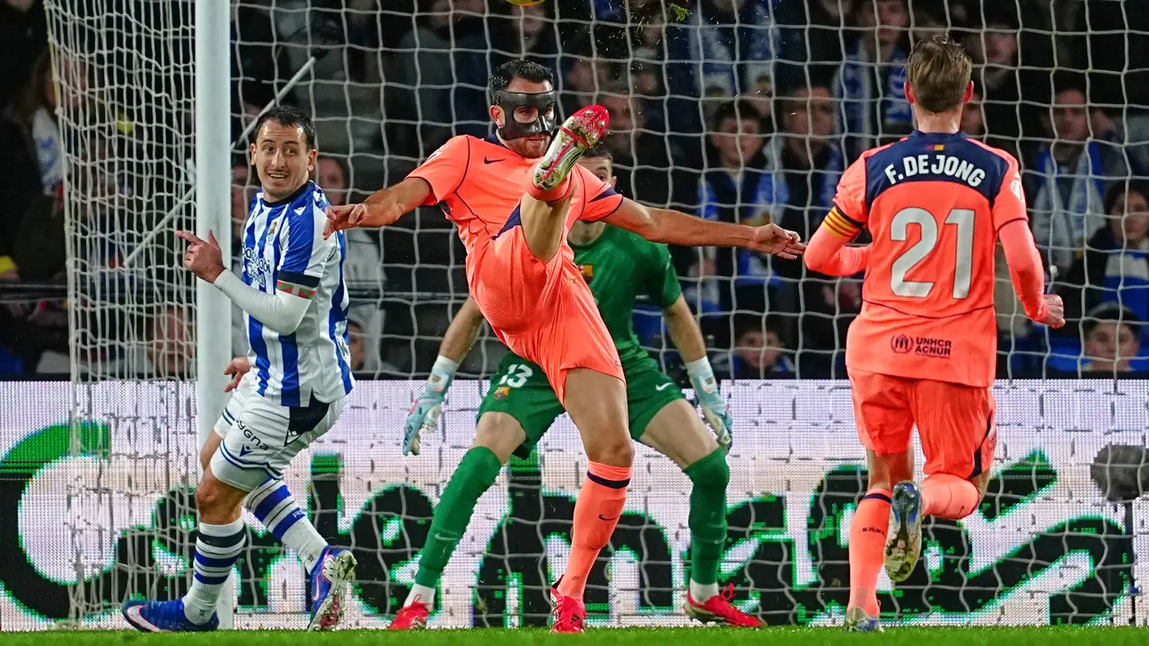 Pemain Barcelona Eric Garcia (tengah) menendang bola di depan pemain Real Sociedad Mikel Oyarzabal