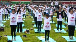 Ratusan warga melakukan gerakan yoga saat mengikuti sesi yoga massal di Stadion Afraha di Nakuru, Kenya (15/6/2019). Acara yoga massal ini untuk memperingati Hari Yoga Internasional. (AFP Photo/Suleiman Mbatiah)