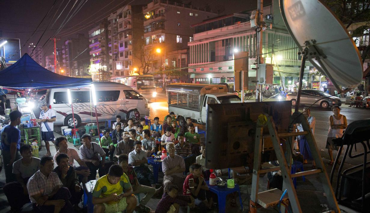 Warga menyaksikan pertandingan antara Real Madrid dan Athletic Club Bilbao lewat televisi dekat warung kopi pinggir jalan di Yangon, Sabtu (13/2/2016).  (AFP / Romeo Gacad)