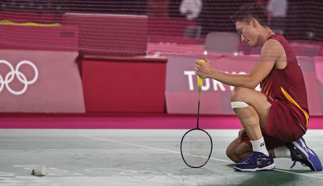 Pebulu tangkis peringkat satu dunia, Kento Momota harus tumbang di laga penentu fase grup ketika menghadapi wakil Korea Selatan, Heo Kwang-hee. Dirinya mengaku tak bisa bermain lepas akibat menerima beban berat untuk sumbangkan medali di rumahnya sendiri. (Foto: AP/Markus Schreiber)