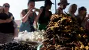 Wisatawan mengambil gambar tarantula goreng yang dijajakan sebuah kios di wilayah Skun, Provinsi Kampong Cham, Kamboja, 14 Maret 2018. Penduduk setempat menyebut, tarantula goreng rasanya seperti daging kepiting. (TANG CHHIN Sothy / AFP)