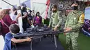 Seorang anak laki-laki mengarahkan senjata yang digunakan oleh Tentara Meksiko dalam pameran yang disebut The Great Force of Mexico di Alun-Alun Zocalo, Mexico City, Meksiko, 20 September 2021. (ALFREDO ESTRELLA/AFP)