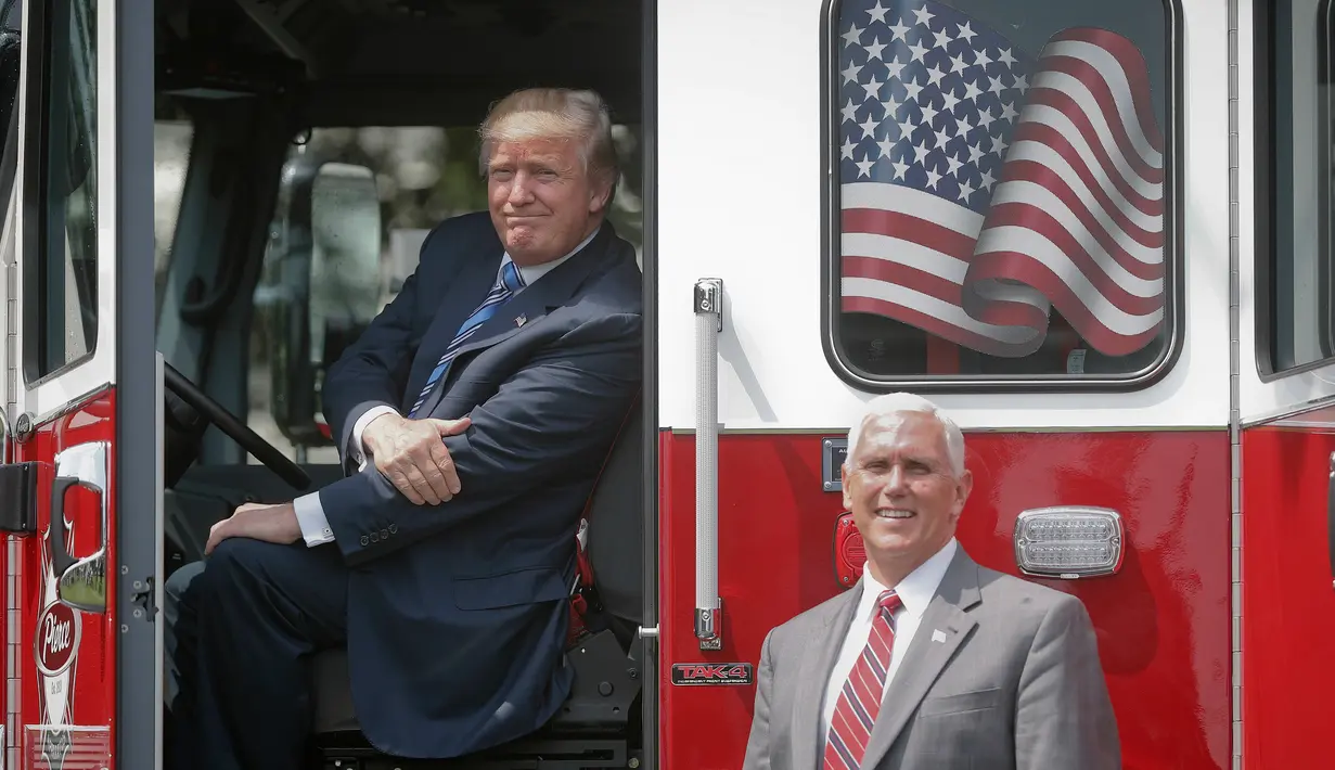 Presiden AS, Donald Trump berpose sambil duduk di sebuah truk pemadam kebakaran saat bersama Wapres Mike Pence menghadiri acara pameran produk bertajuk "Made in America" di Gedung Putih, Washington, Senin (17/7). (AP Photo/Pablo Martinez Monsivais)