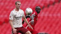 Bek Arsenal, Rob Holding, berebut bola dengan penyerang Liverpool, Sadio Mane, pada laga Community Shield 2020 di Stadion Wembley, Sabtu (29/8/2020) malam WIB. Arsenal menang 5-4 atas Liverpool lewat adu penalti. (Andrew Couldridge/Pool via AP)