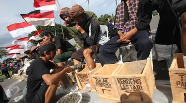 Petani Kendeng berunjuk rasa memasung kaki dengan semen di depan Istana Negara, Jakarta, Rabu (15/3). Unjuk rasa mereka telah memasuki hari ketiga. (Liputan6.com/Immanuel Antonius)
