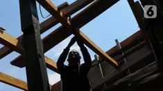 Tukang kayu memperbaiki kapal motor di Pelabuhan Kalibaru, Jakarta, Rabu (8/3/2023). Tukang kayu mengalami kesulitan bahan baku yang mulai jarang. (merdeka.com/Imam Buhori)