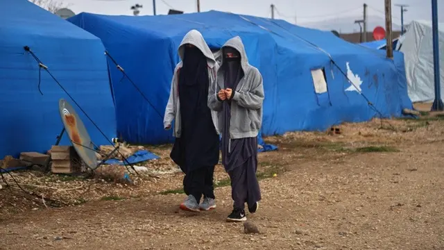 Dua perempuan berjalan di antara tenda-tenda di kamp Al-Roj, salah satu fasilitas penahanan yang menampung ribuan anggota kelompok ISIS beserta keluarga mereka, di wilayah al-Malikiyah, Suriah timur laut. Foto diambil pada Kamis, 29 Januari 2026.