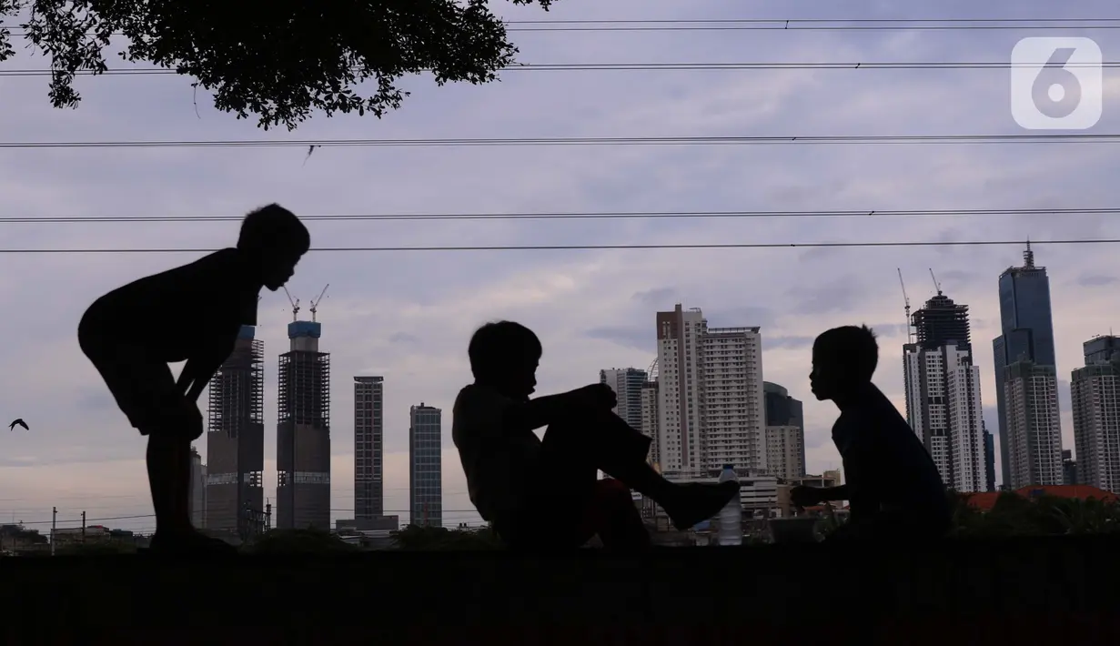 Anak-anak dengan latar gedung bertingkat bermain di Jakarta, Sabtu (19/3/2022). Bank Indonesia (BI) memperkirakan pertumbuhan ekonomi Indonesia akan meningkat lebih tinggi, pada kisaran 4,7 persen hingga 5,5 persen, dari pertumbuhan 3,69 persen pada 2021. (Liputan6.com/Angga Yuniar)