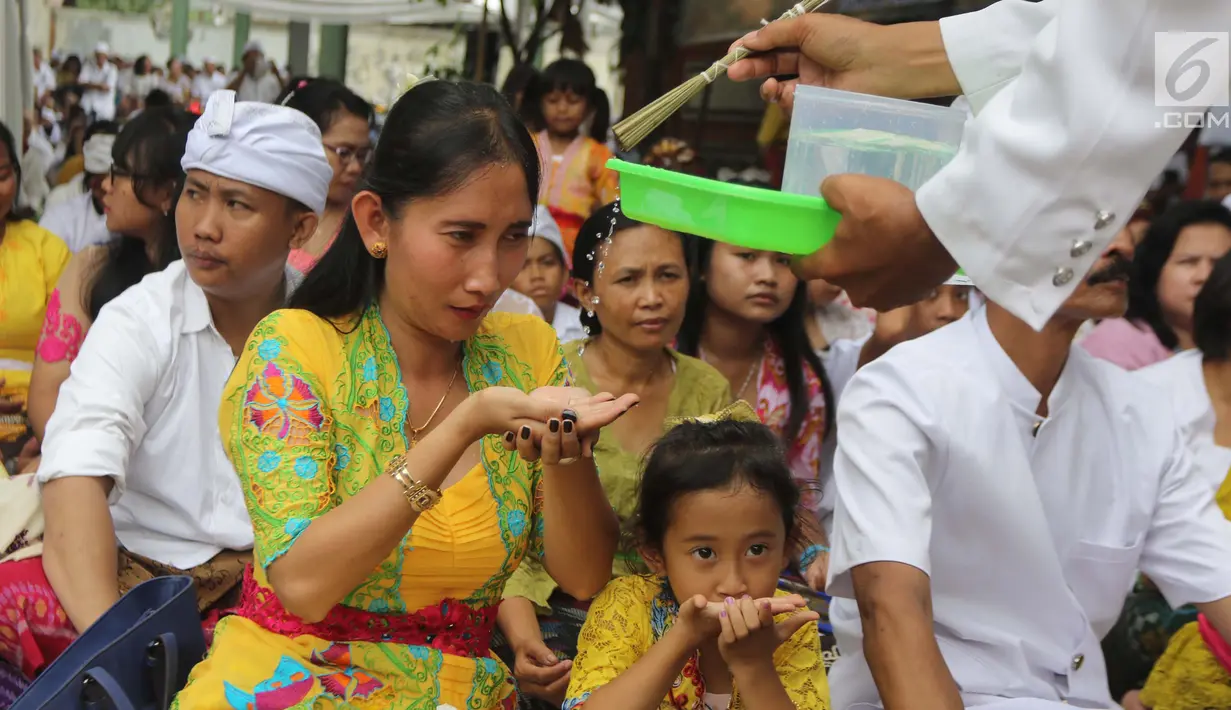 Pemuka agama Hindu memberikan air suci saat upacara Tawur Kesanga di Pura Aditya Jaya, Rawamangun, Jakarta, Jumat (16/3). (Liputan6.com/Arya Manggala)