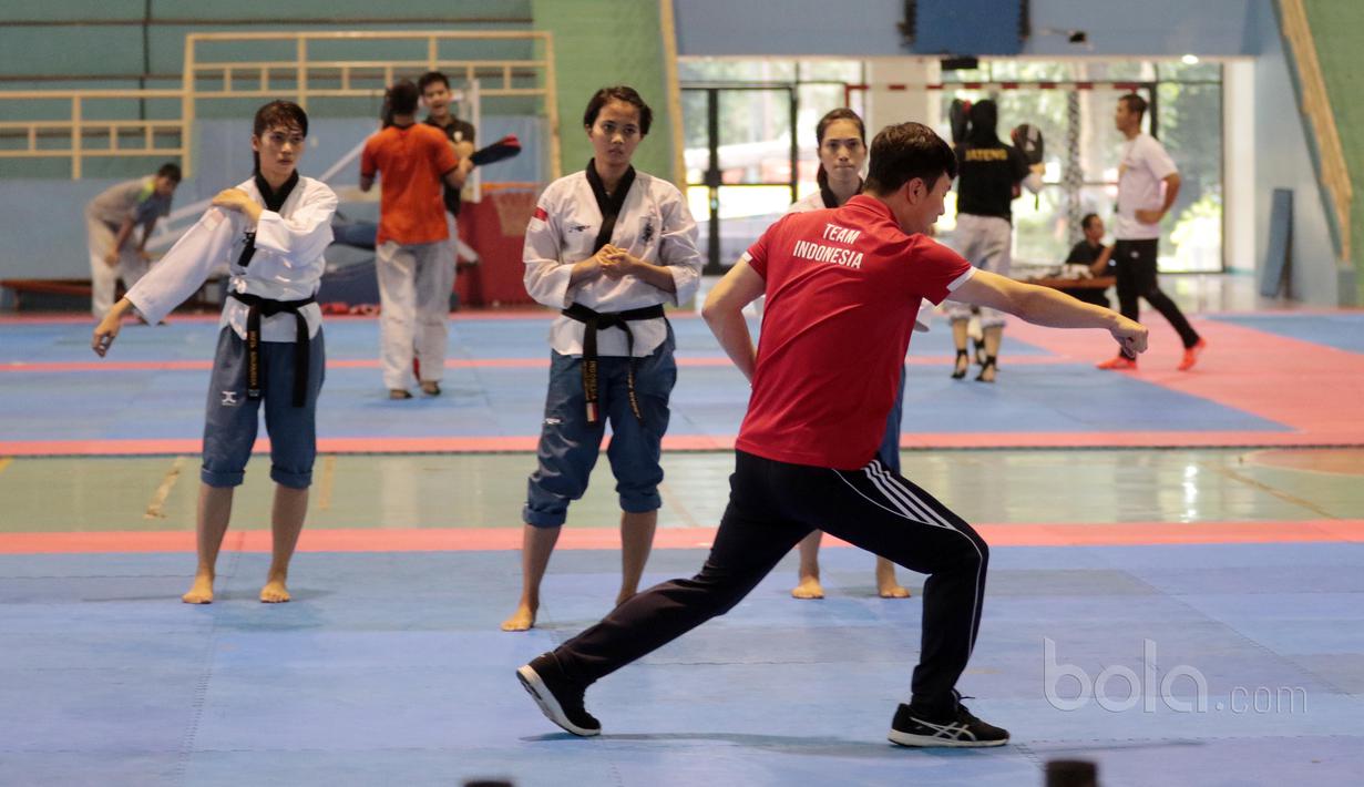 Pelatih asal Korea memberikan arahan kepada Tim putri Taekwondo Indonesia yang ikut kategori Poomsae saat berlatih gerakan dasar di GOR Popki, Cibubur (13/7/2017). (Bola.com/Nicklas Hanoatubun)