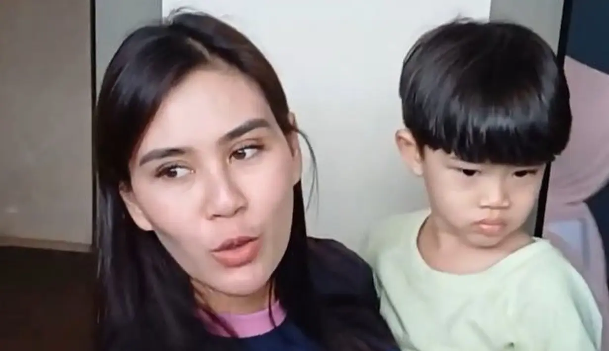 Turun dari mobil, istri Jeje Govinda itu mengendong anak laki-lakinya. Ia mengaku sedang menunggu kostum yang akan digunakan oleh sang buah hati. [Foto: KapanLagi.com/Fikri Alfi Rosyadi]