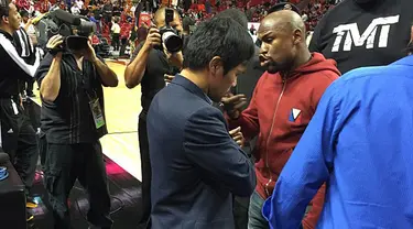 Floyd Mayweather Jr menghampiri Manny Pacquiao saat menyaksikan pertandingan NBA antara Miami Heat dan Milwaukee Bucks, AS, Rabu (28/1/2015). (Dailymail)