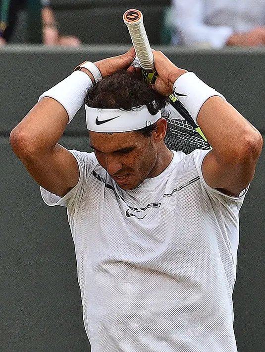 Petenis Spanyol, Rafael Nadal bereaksi saat melawan petenis Luksemburg, Giller Muller pada perempat final Wimbledon 2017 di London, Senin (10/7). Nadal dikalahkan Mueller dalam duel sepanjang lima set selama empat jam dan 47 menit. (Glyn KIRK / AFP)
