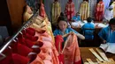 Penjahit menggantung pakaian upacara yang akan digunakan Paus Fransiskus saat mengunjungi Thailand, Bangkok, Jumat (8/11/2019). Selain untuk Paus Fransiskus, mereka juga menjahit hampir 200 jubah untuk uskup. (AP Photo/Gemunu Amarasinghe)