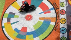 Pengendara melintasi mural yang menghiasi halaman depan Kantor Kelurahan Tegal Alur, Jakarta Barat, Rabu (18/4). Mural tersebut dibuat oleh petugas Penanganan Prasarana dan Sarana Umum (PPSU). (Liputan6.com/Arya Manggala)